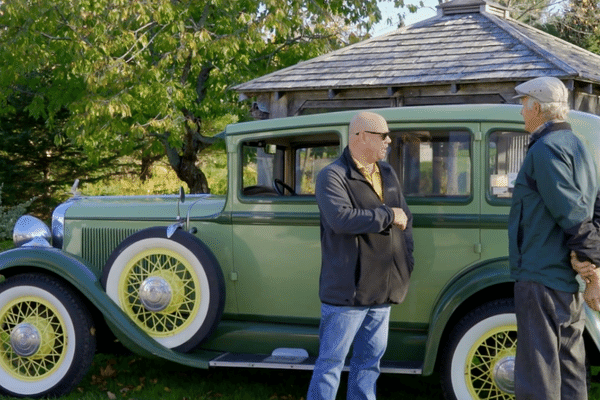 two men standing in front of a green classic car in Nova Scotia