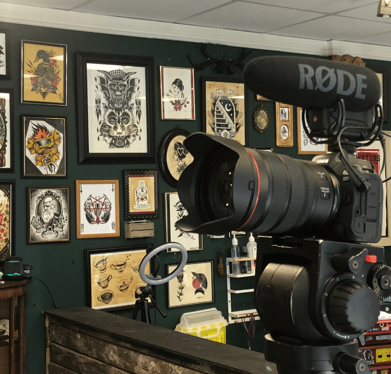 camera in front of wall of flash in tattoo shop