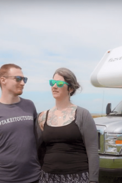 couple standing in front of an RV